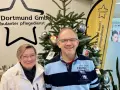Zwei Mitarbeiter des ambulanten Pflegedienstes APD Dortmund stehen vor einem Weihnachtsbaum. Bei Fragen zum pflegedienst beschwerdestelle nrw sind sie gerne für Sie da.