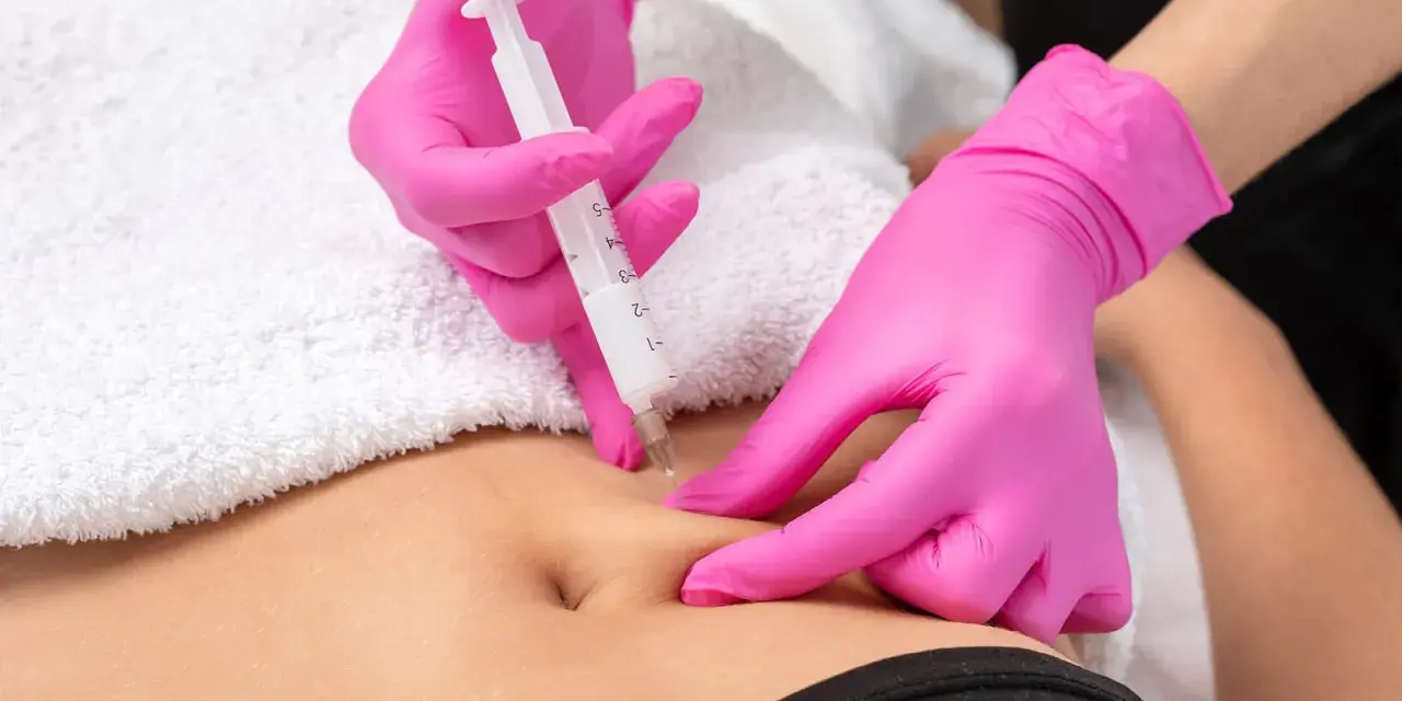 Hände in pinken Handschuhen spritzen unter die Haut. Eine Spritze wird präzise angesetzt, um eine Behandlung durchzuführen.