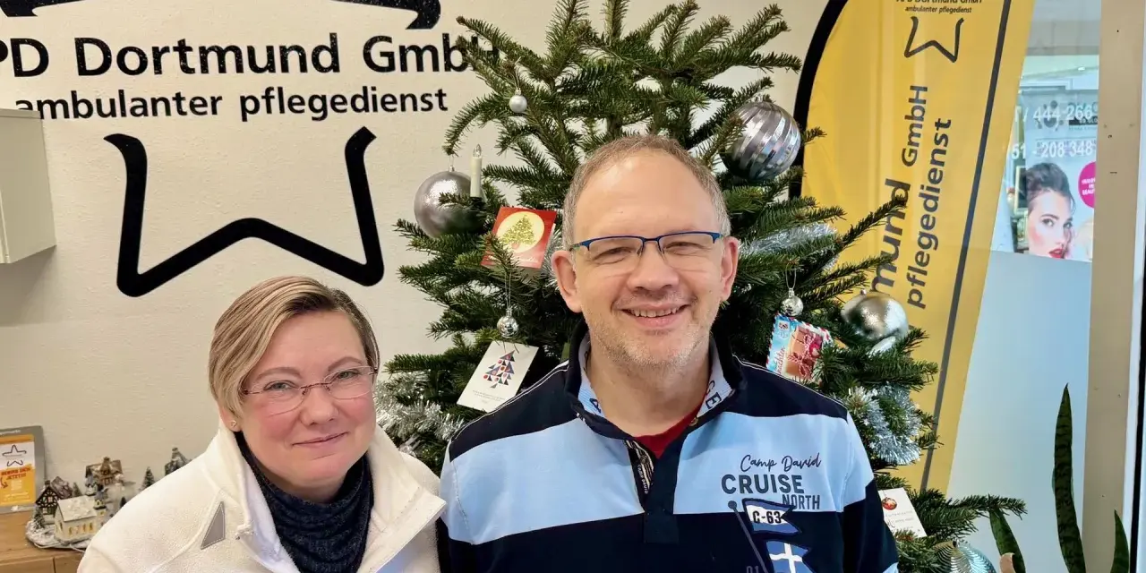 Zwei Mitarbeiter des ambulanten Pflegedienstes APD Dortmund stehen vor einem Weihnachtsbaum. Bei Fragen zum pflegedienst beschwerdestelle nrw sind sie gerne für Sie da.